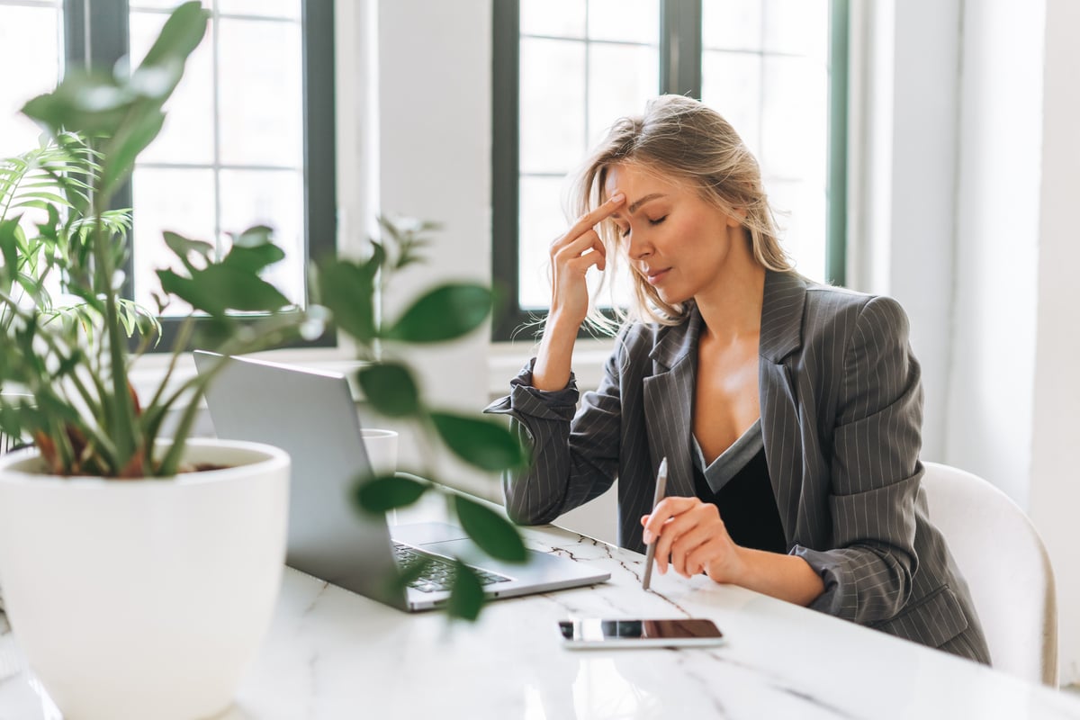 Young tired blonde woman with long hair at office